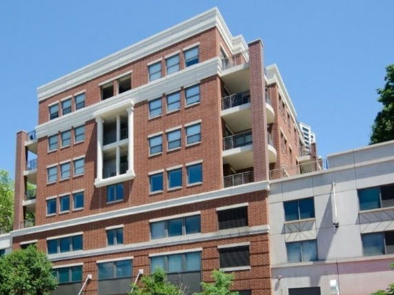 Front view of a multi-story brick building with balconies.