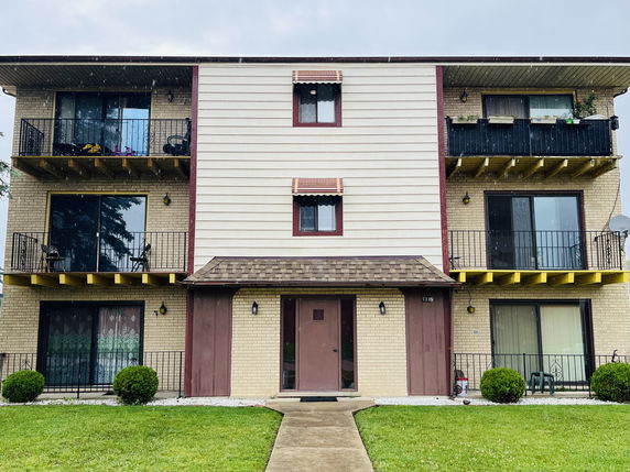 Front view of a multi-story residential building with balconies.