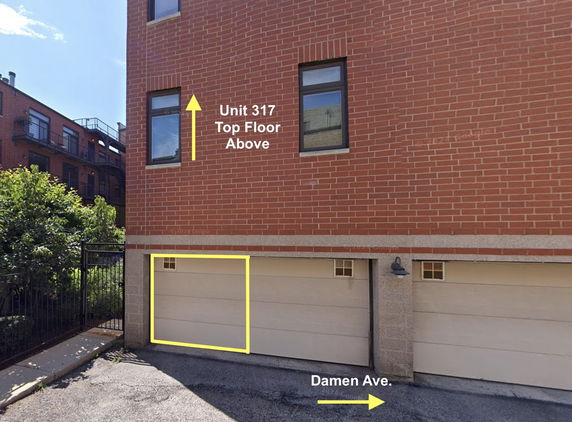 Front view of a brick building with multiple windows and a ground level garage.