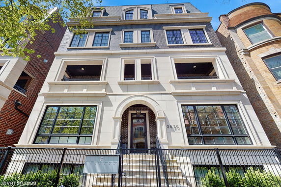 Front view of a multi-story residential building with multiple windows and a central entrance.