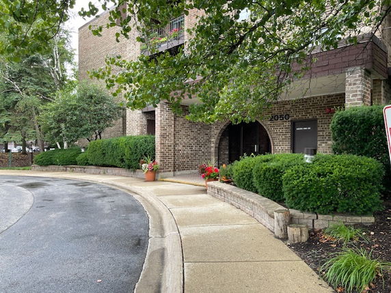 Front view of a brick apartment building with an arched entryway.