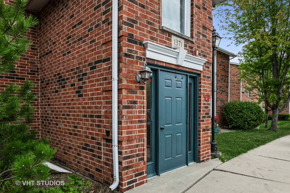 Front view of a two-story brick building with a blue door.