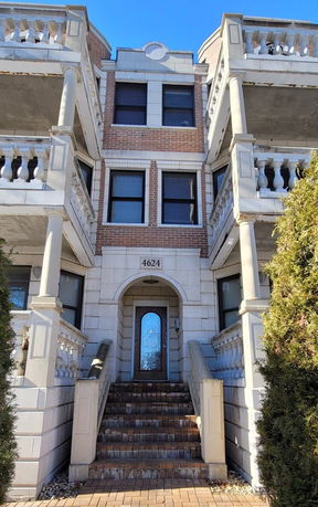 Front view of a multi-story building with brick and stone facade.
