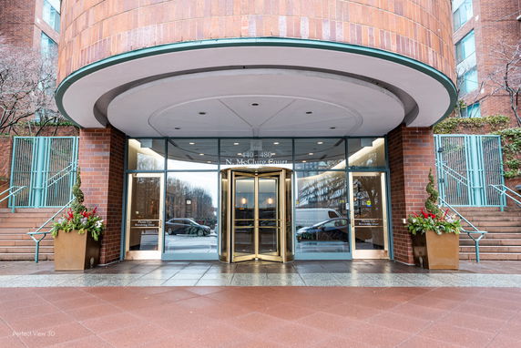 Entrance of a building with a revolving door and glass facade.