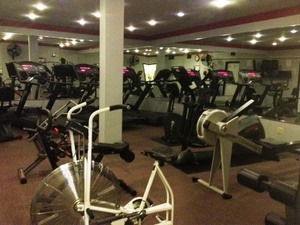 Indoor gym area with exercise equipment including treadmills and stationary bikes.