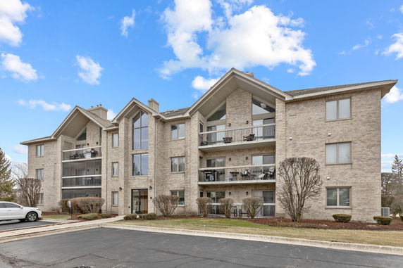 Front view of a multi-story apartment building with balconies.