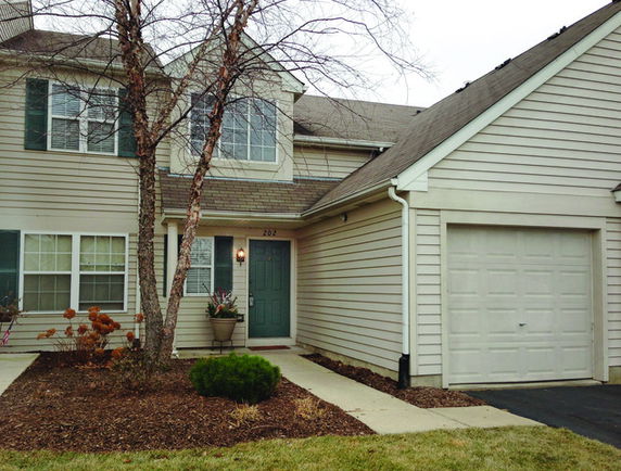 Front view of a two-story house with a garage on the right side.