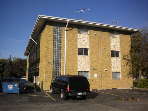 Front view of a multi-story building with brick exterior and glass windows.