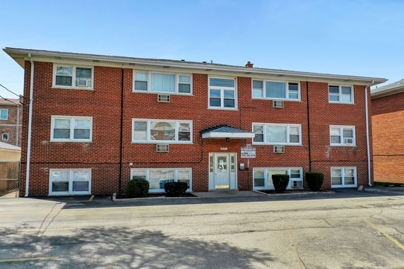 Front view of a three-story brick apartment building.