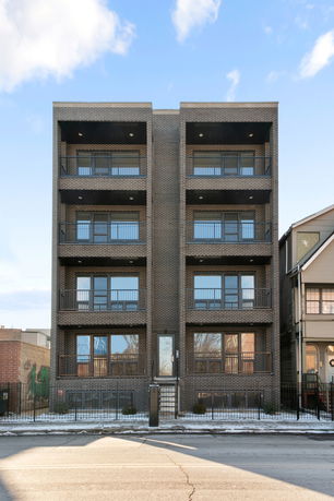 Front view of a multi-story brick building with balconies.