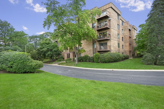 Exterior view of a multi-story brick apartment building with balconies.