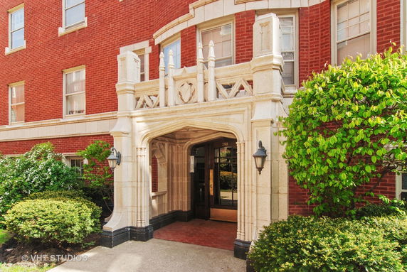 Front view of a brick building with an ornate stone entrance.