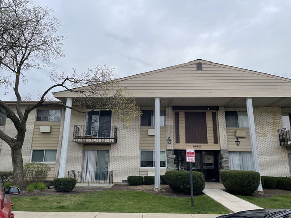 Front view of a two-story apartment building with brick and siding exterior.