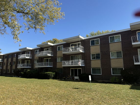 Front view of a multi-story apartment building with balconies.