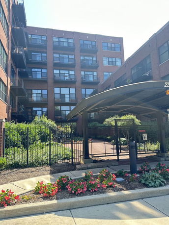 Front view of a multi-story brick apartment building with balconies.