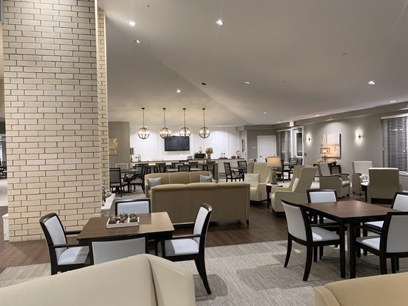 Interior view of a club house area with tables, chairs, and lounge seating.