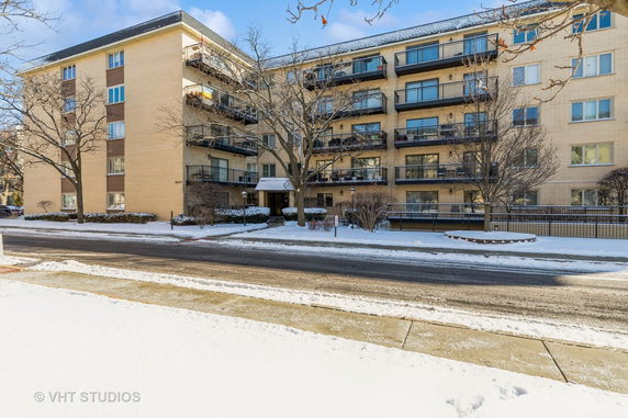 Front view of a multi-story apartment building with balconies.