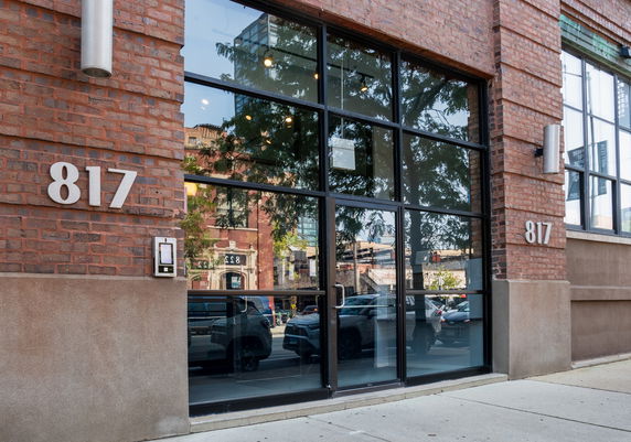 Front view of a brick building with large glass windows and the number 817 displayed.