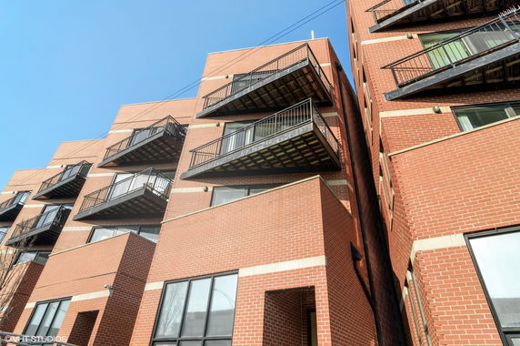 Front view of a brick apartment building with multiple balconies.