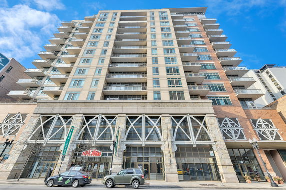 Front view of a multi-story mixed-use building with balconies.