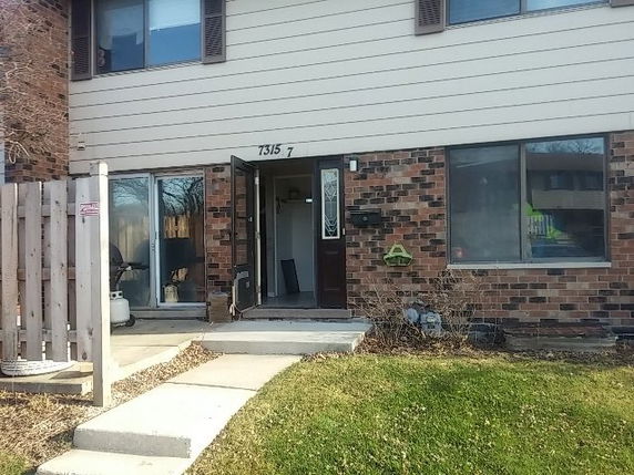 Front view of a two-story townhouse with brick and siding exterior.