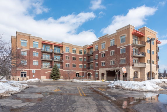 Front view of a four-story brick apartment building with multiple balconies.