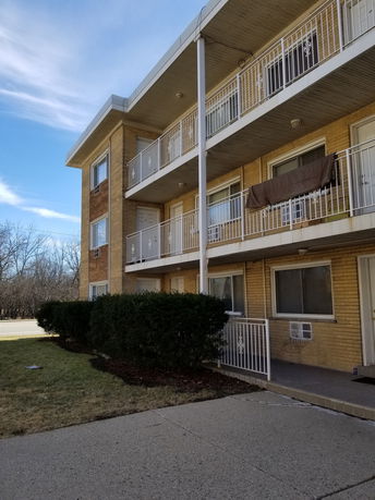 Front view of a three-story apartment building with balconies.