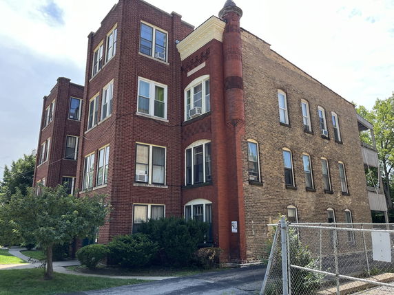 Front view of a multi-story brick apartment building.