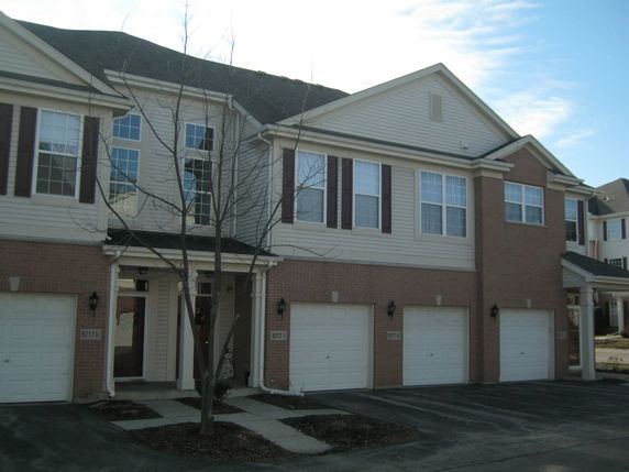 Front view of a two-story townhouse with attached garages.