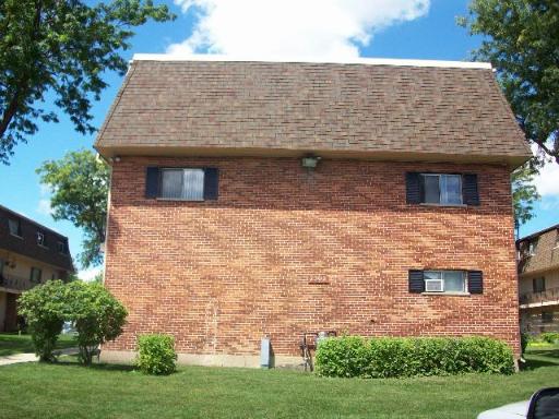 Front view of a two-story brick building with a gabled roof.