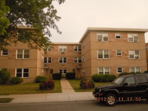 Front view of a multi-story apartment building with a brick facade.