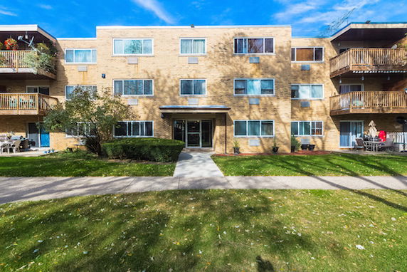 Front view of a three-story apartment building with balconies.