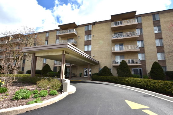 Front view of a multi-story residential building with a covered entrance.