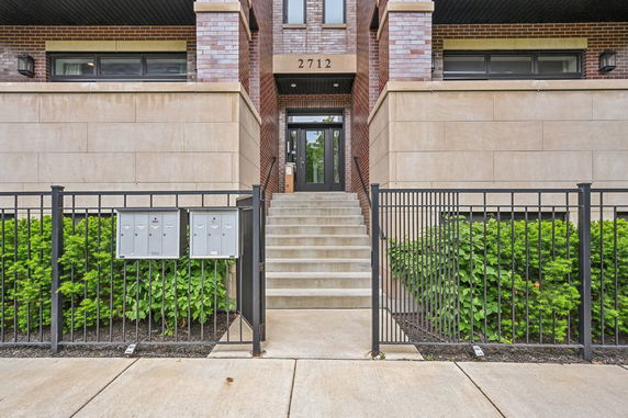 Front view of a multi-story building with an entrance staircase.