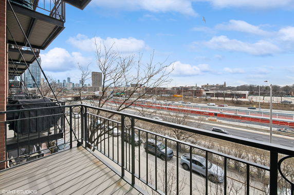 View from a balcony overlooking a highway and cityscape in the distance.