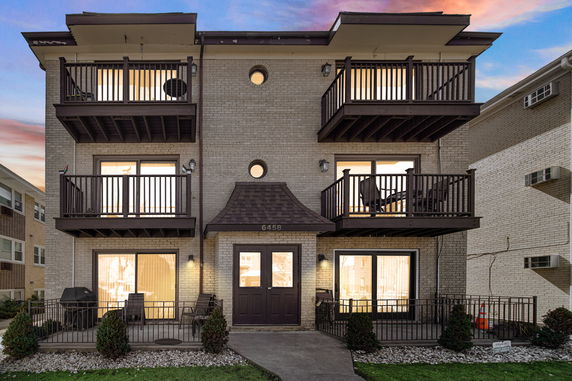 Front view of a multi-story brick building with multiple balconies.