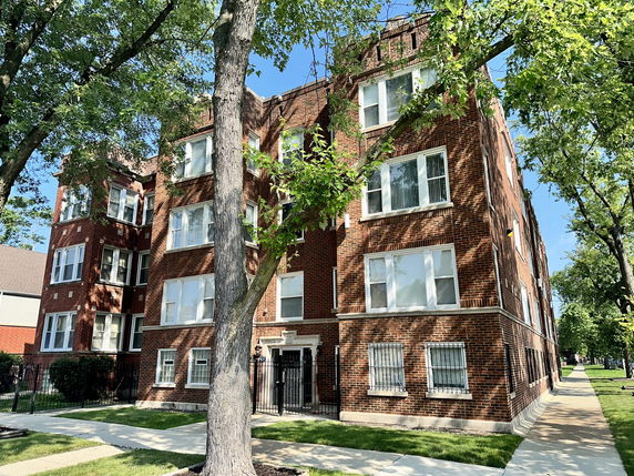 Front view of a multi-story brick apartment building.