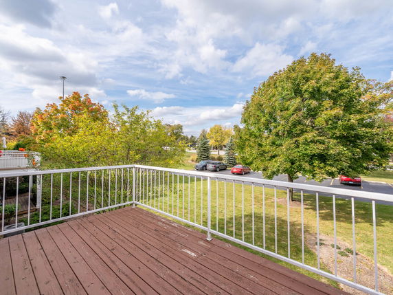 View from a balcony showing a grassy area and parking lot.