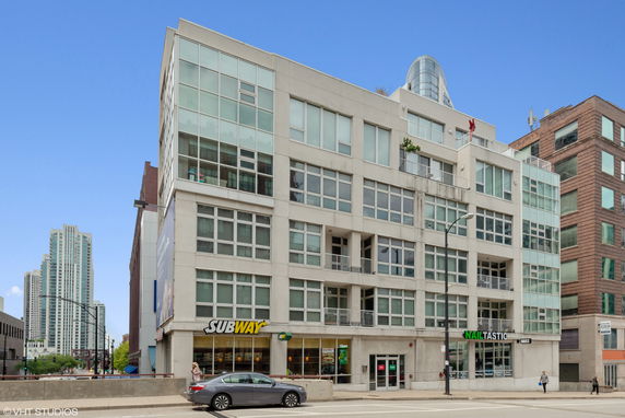 Front view of a multi-story building with large windows and commercial spaces on the ground floor.