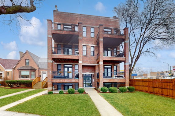 Front view of a multi-story brick building with balconies.