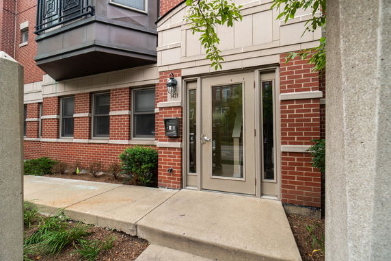 Front view of a brick building entrance with a glass door.