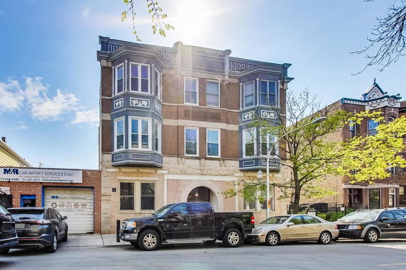 Front view of a multi-story building with bay windows and decorative details.