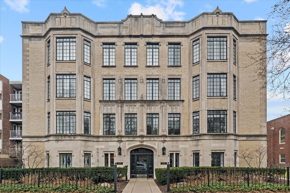 Front view of a multi-story building with large windows and decorative facade.