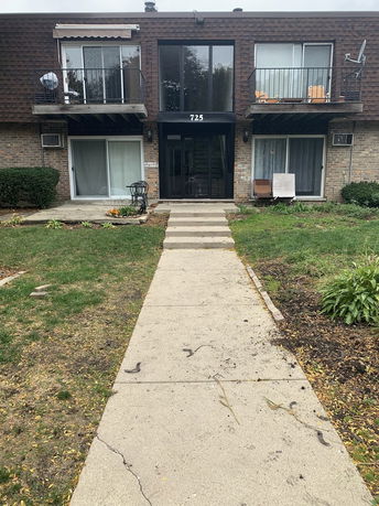 Front view of a two-story residential building with balconies and a central entrance.