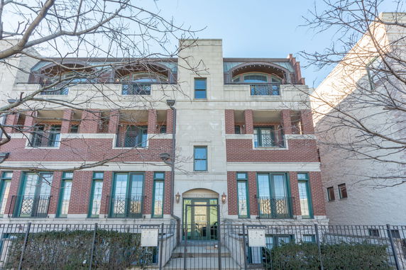 Front view of a multi-story brick building with balconies.
