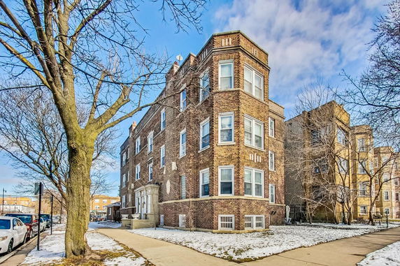 Front view of a multi-story brick building with multiple windows.