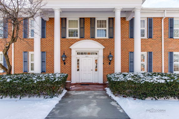 Front view of a two-story brick house with white columns and a central entrance.
