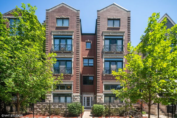 Front view of a multi-story brick building with modern windows and small balconies.