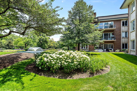 Backyard view of a multi-story building with a fountain and garden.
