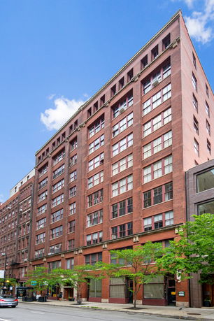 Front view of a multi-story brick building with numerous windows.